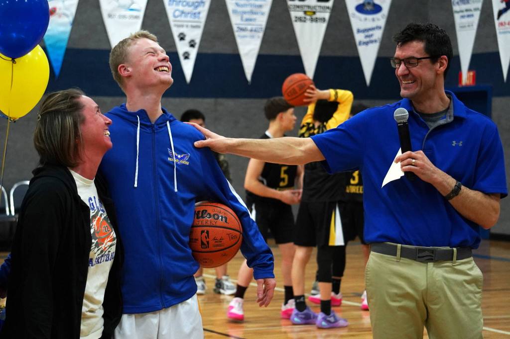 Cook Inlet Academys Jeremy Dillingham laughs with his mother and coach Ben McGarry as hes honored during senior night festivities at Cook Inlet Academy in Soldotna, Alaska, on Tuesday, Feb. 13, 2024. (Jake Dye/Peninsula Clarion)