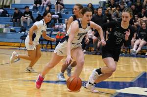 Soldotnas Kaytlin McAnelly, backed by teammate Izzy Cruz, moves with the ball against defensive play by Houstons Andi Robinson during a basketball game at Soldotna High School in Soldotna, Alaska, on Friday, Feb. 23, 2024. (Jake Dye/Peninsula Clarion)