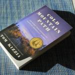 A copy of Tom Kizzias Cold Mountain Path rests on a table on Thursday, Feb. 29, 2024 in Juneau, Alaska. (Ashlyn OHara/Peninsula Clarion)