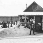 Ray Sandstrom photo courtesy of the KPC historical photo archive
Floyd Pappy Keeler, standing in 1951 in front of his cabin on the homestead of his son Jack, is holding a girl who is likely Barbara Sandstrom, while her sister Rhoda, standing by a truck, looks on.