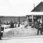 Floyd Pappy Keeler, standing in 1951 in front of his cabin on the homestead of his son Jack, is holding a girl who is likely Barbara Sandstrom, while her sister Rhoda, standing by a truck, looks on. Ray Sandstrom photo courtesy of the KPC historical photo archive.