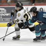 Kenai River Brown Bears forward Samuel Sisik makes a centering pass past Anchorage Wolverines defenseman Brock Devlin on Saturday, March 2, 2024, at the Soldotna Regional Sports Complex in Soldotna, Alaska. (Photo by Jeff Helminiak/Peninsula Clarion)