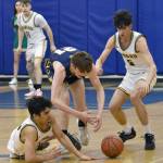 Sewards Nick Ambrosiani and Van Shank and Homers CJ Burns battle for the ball Saturday, March 9, 2024, at the Peninsula Conference tournament at Homer High School in Homer, Alaska. (Photo by Jeff Helminiak/Peninsula Clarion)