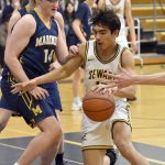 Sewards Nick Ambrosiani drives against Homers Einar Pederson on Saturday, March 9, 2024, at the Peninsula Conference tournament at Homer High School in Homer, Alaska. (Photo by Jeff Helminiak/Peninsula Clarion)