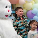 The Easter Bunny poses for photos with Parker and Juniper Parrish during the Easter Eggstravaganza at Nikiski Community Recreation Center in Nikiski, Alaska, on Saturday, March 23, 2024. (Jake Dye/Peninsula Clarion)