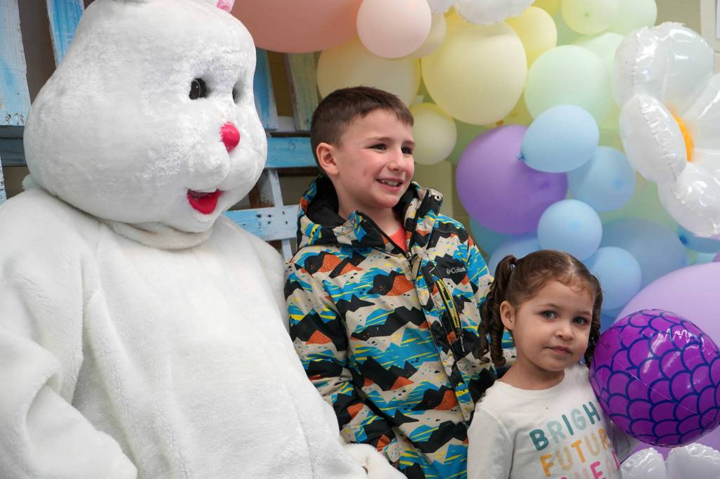 The Easter Bunny poses for photos with Parker and Juniper Parrish during the Easter Eggstravaganza at Nikiski Community Recreation Center in Nikiski, Alaska, on Saturday, March 23, 2024. (Jake Dye/Peninsula Clarion)