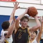 Ninilchik's Kade McCorison moves to shoot over attempted blocks by Aniak's William and Troy Morgan during a basketball game at Ninilchik School in Ninilchik, Alaska, on Wednesday, Feb. 14, 2024. (Jake Dye/Peninsula Clarion)