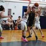 Ninilchiks Kade McCorison moves to shoot over attempted blocks by Aniaks William and Troy Morgan during a basketball game at Ninilchik School in Ninilchik, Alaska, on Wednesday, Feb. 14, 2024. (Jake Dye/Peninsula Clarion)