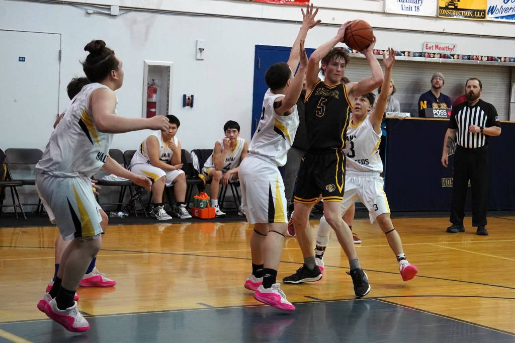 Ninilchiks Kade McCorison moves to shoot over attempted blocks by Aniaks William and Troy Morgan during a basketball game at Ninilchik School in Ninilchik, Alaska, on Wednesday, Feb. 14, 2024. (Jake Dye/Peninsula Clarion)