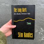 A copy of Slim Randles The Long Dark: An Alaska Winters Tale is held on Wednesday, April 27, 2024, near Soldotna, Alaska. (Ashlyn OHara/Peninsula Clarion)