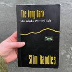 A copy of Slim Randles The Long Dark: An Alaska Winters Tale is held on Wednesday, April 27, 2024, near Soldotna, Alaska. (Ashlyn OHara/Peninsula Clarion)
