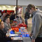 A visitor to the 2023 Kenai Peninsula Job and Career Fair speaks to representatives of Paradisos Restaurant on Thursday, April 6, 2023 at the Old Carrs Mall in Kenai, Alaska. (Jake Dye/Peninsula Clarion)