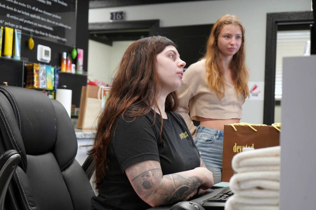 Vanessa Uei checks in guests during a grand opening for AK Wellness & Tanning in Kenai, Alaska, on Saturday, April 6, 2024. (Jake Dye/Peninsula Clarion)