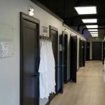 A hallway is lined with rooms and robes at AK Wellness & Tanning in Kenai, Alaska, on Saturday, April 6, 2024. (Jake Dye/Peninsula Clarion)