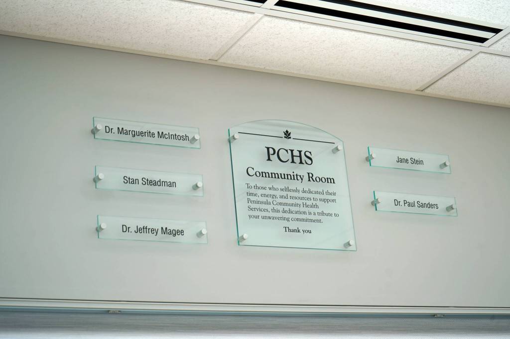 A plaque dedicates the Community Room to five people who played significant roles in the organizations history at Peninsula Community Health Services in Soldotna, Alaska, is seen on Monday, April 15, 2024. (Jake Dye/Peninsula Clarion)