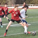 Kenai Centrals Zane James and Homers Reid Rauch battle for the ball Tuesday, April 16, 2024, at Ed Hollier Field at Kenai Central High School in Kenai, Alaska. (Photo by Jeff Helminiak/Peninsula Clarion)