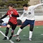 Kenai Centrals Sawyer Vann and Homers Lucas Story battle for the ball Tuesday, April 16, 2024, at Ed Hollier Field at Kenai Central High School in Kenai, Alaska. (Photo by Jeff Helminiak/Peninsula Clarion)
