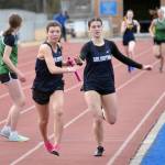 Soldotnas Anaulie Sedivy hands off to Annie Burns in the 1,600-meter relay Saturday, April 20, 2024, at the Soldotna Invitational at Soldotna High School in Soldotna, Alaska. (Photo by Jeff Helminiak/Peninsula Clarion)
