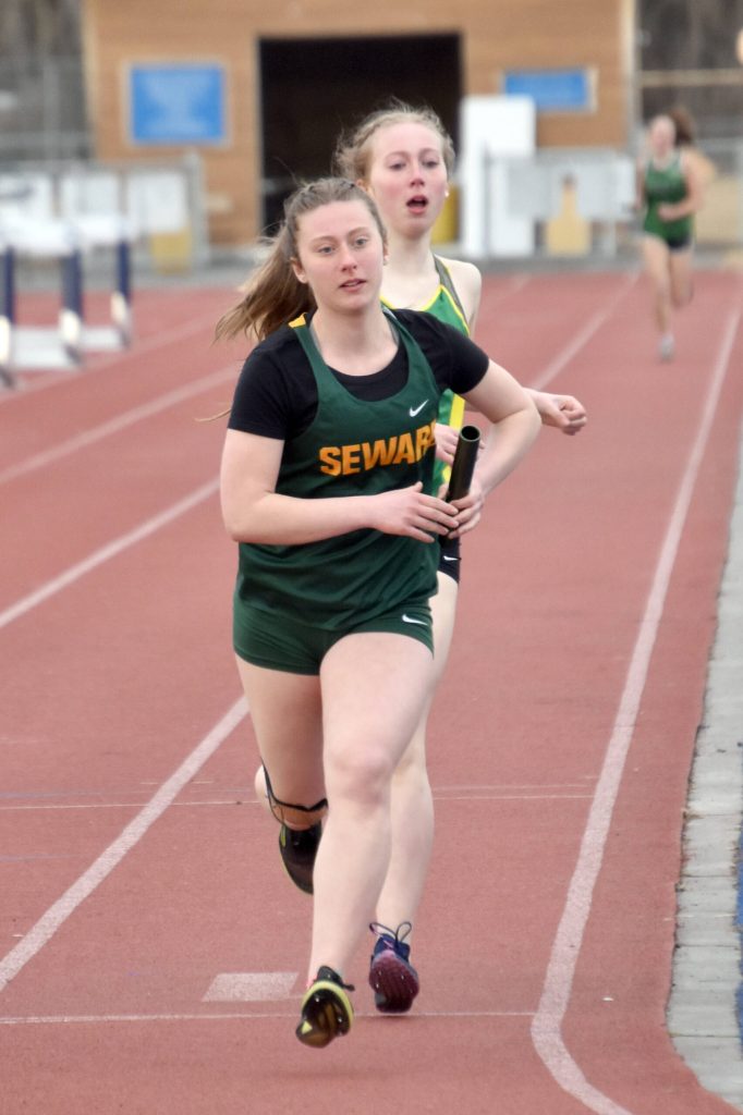 Sewards Juniper Ingalls hands the baton to Hailey Ingalls in the 3,200-meter relay Saturday, April 20, 2024, at the Soldotna Invitational at Soldotna High School in Soldotna, Alaska. (Photo by Jeff Helminiak/Peninsula Clarion)
