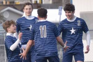 Soldotna's Andrew Arthur (right) celebrates his goal with teammates Owen Buckbee, Zac Buckbee and Nuno Venturi on Tuesday, April 23, 2024, at Soldotna High School in Soldotna, Alaska. (Photo by Jeff Helminiak/Peninsula Clarion)