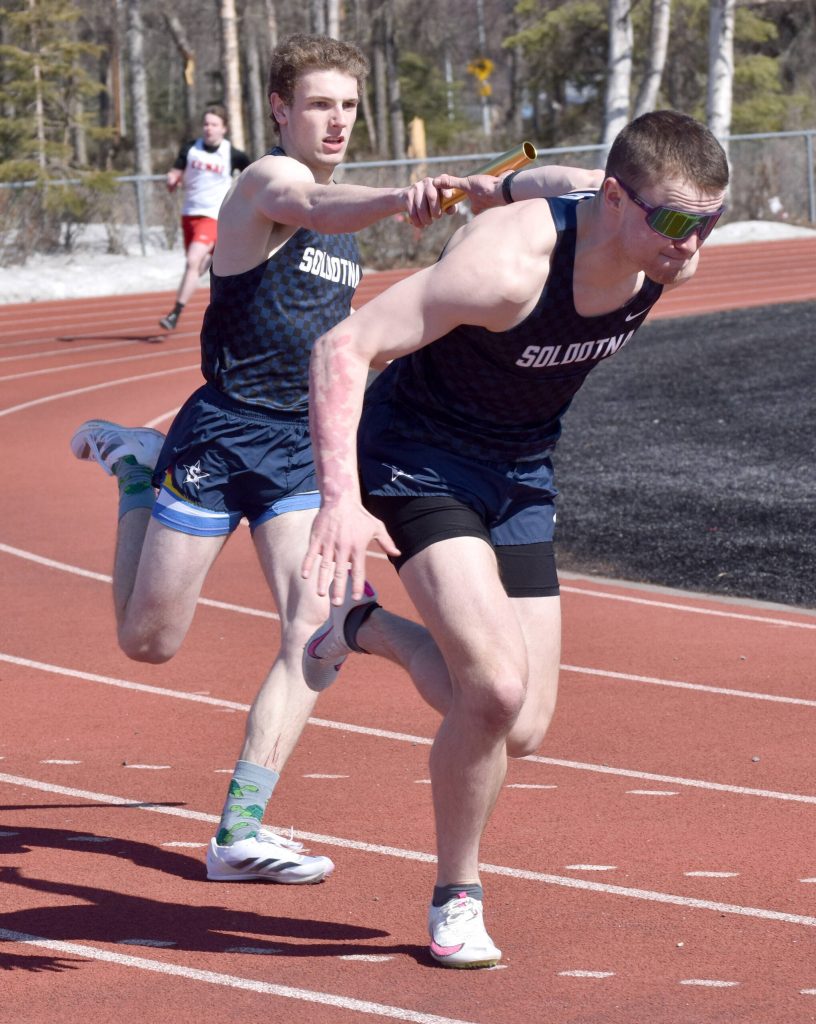 Soldotnas James Innes hands to Jeren Nash on Soldotnas winning 400-meter relay Saturday, April 27, 2024, at the Kenai Invitational at Kenai Central High School in Kenai, Alaska. (Photo by Jeff Helminiak/Peninsula Clarion)