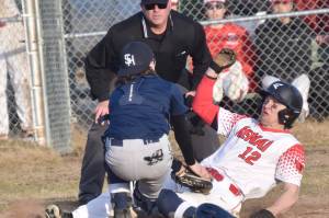Kenai Central's Zane Pellegrom slides under the tag of Soldotna's Ari Miller on Monday, April 29, 2024, at the Kenai Little League fields in Kenai, Alaska. (Photo by Jeff Helminiak/Peninsula Clarion)
