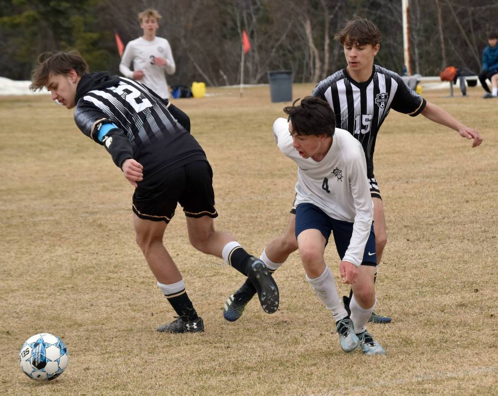Homers Reid Rauch dribbles against Nikiskis Seth Payne and Gavin Carmody on Saturday, May 4, 2024, at Nikiski Middle-High School in Nikiski, Alaska. (Photo by Jeff Helminiak/Peninsula Clarion)