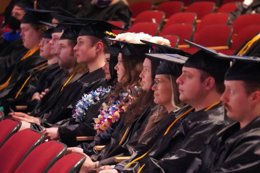 Graduates of Kenai Peninsula College listen to speakers during the 54th Annual Kenai Peninsula College Commencement Ceremony at Kenai Central High School in Kenai, Alaska, on Thursday, May 9, 2024. (Jake Dye/Peninsula Clarion)