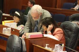 Rep. Jamie Allard, R-Eagle River, and Rep. Mike Prax, R-North Pole, discuss a proposed amendment to a bill sponsored by Allard restricting transgender students participation in school sports during a House floor session on Thursday, May 9, 2024. (Mark Sabbatini / Juneau Empire)