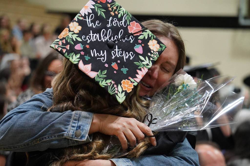 Nikiski Middle/High School graduates hold tightly to their supporters during a graduation ceremony in the schools gym in Nikiski, Alaska, on Wednesday, May 15, 2024. (Jake Dye/Peninsula Clarion)