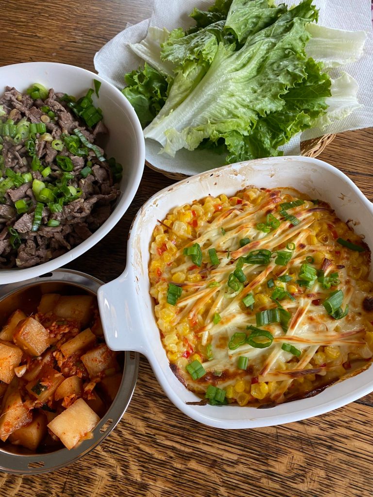 Corn cheese is served alongside grilled beef, kimchi and lettuce. (Photo by Tressa Dale/Peninsula Clarion)