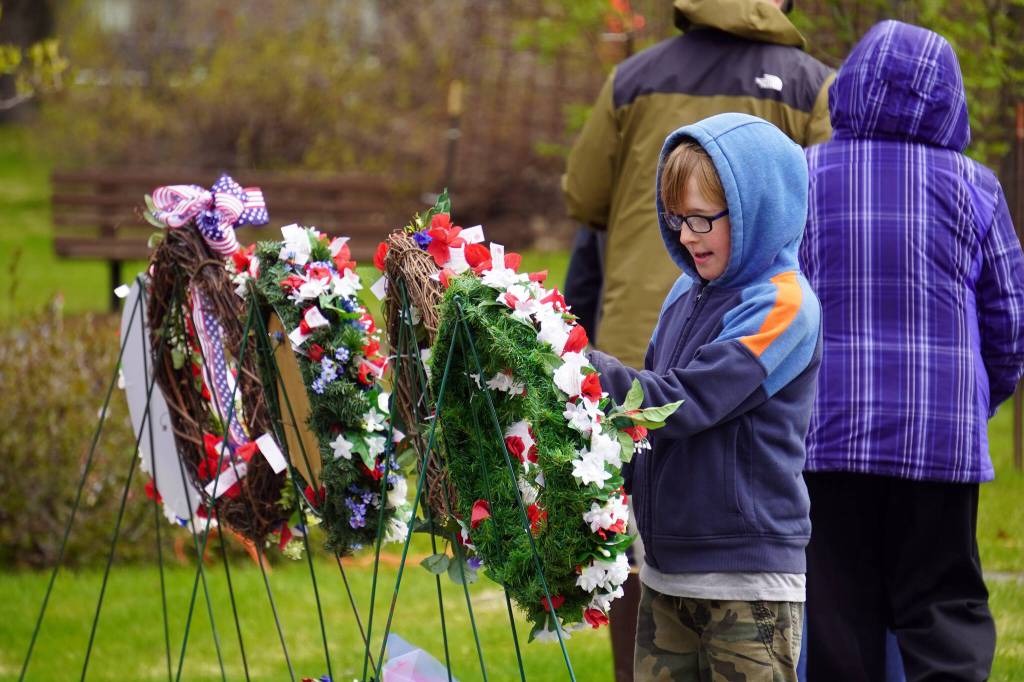 Poppies are affixed to wreaths during a Memorial Day ceremony at Leif Hanson Memorial Park in Kenai, Alaska, on Monday, May 27, 2024. (Jake Dye/Peninsula Clarion)