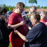 Coach Heidi Renner awards athletes from the Central Kenai Peninsulas Special Olympics Alaska swim team with ribbons they earned in recent competition at Soldotna Creek Park in Soldotna, Alaska, on Tuesday, June 4, 2024. (Jake Dye/Peninsula Clarion)