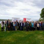 Attendees gather for photos at the ribbon-cutting for the Kenai River Bluff Stabilization Project on the bluff above the Kenai River in Kenai, Alaska, on Monday, June 10, 2024. (Jake Dye/Peninsula Clarion)