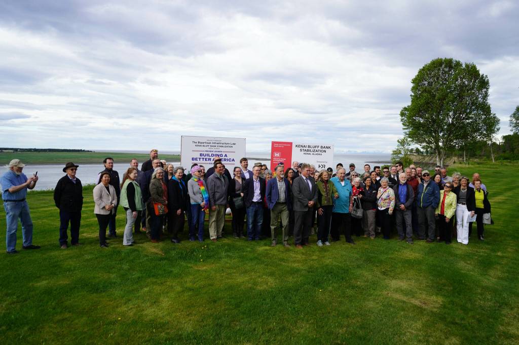 Attendees gather for photos at the ribbon-cutting for the Kenai River Bluff Stabilization Project on the bluff above the Kenai River in Kenai, Alaska, on Monday, June 10, 2024. (Jake Dye/Peninsula Clarion)