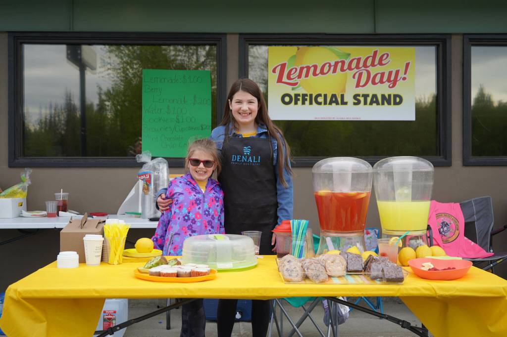 Maci Daniel, right, operates her lemonade stand, Denali Sweets, outside Denali Family Dentistry in Kenai, Alaska, during Lemonade Day on Saturday, June 8, 2024. (Jake Dye/Peninsula Clarion)