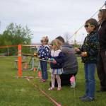 Leah Eskelin, a park ranger with the U.S. Fish and Wildlife Service, oversees children as they practice casting during the Kenai River Fair at Soldotna Creek Park in Soldotna, Alaska, on Saturday, June 7, 2024. (Jake Dye/Peninsula Clarion)