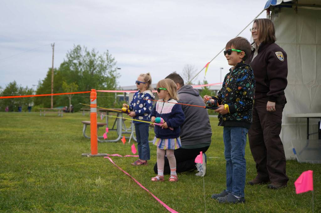 Leah Eskelin, a park ranger with the U.S. Fish and Wildlife Service, oversees children as they practice casting during the Kenai River Fair at Soldotna Creek Park in Soldotna, Alaska, on Saturday, June 7, 2024. (Jake Dye/Peninsula Clarion)