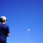Nathan Nelson directs a kite flying dozens of feet up in the sky above Millennium Square in Kenai, Alaska, during the Kenai Kite Festival on Saturday, June 15, 2024. (Jake Dye/Peninsula Clarion)