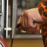 Grey Wilson, of Wilsons Proper Edge, sharpens a knife at Soldotna Creek Park in Soldotna, Alaska, on Wednesday, June 19, 2024. (Jake Dye/Peninsula Clarion)