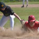 Napoleon (Ohio) River Bandits player Kadyn Radzik dives back into first safely in front of Service first baseman Owen Hickman in the final of the Lance Coz Wood Bat Tournament on Monday, June 24, 2024, at Coral Seymour Memorial Park in Kenai, Alaska. (Photo by Jeff Helminiak/Peninsula Clarion)