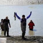 A fisher celebrates success with a sockeye salmon in hand during the opening day of the personal use dipnet fishery at the mouth of the Kasilof River in Alaska, on Tuesday, June 25, 2024. (Jake Dye/Peninsula Clarion)