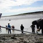 A fisher extracts a sockeye salmon from his net during the opening day of the personal use dipnet fishery at the mouth of the Kasilof River in Alaska, on Tuesday, June 25, 2024. (Jake Dye/Peninsula Clarion)