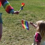 A young girl waves a Pride flag at the Saturday, June 22<ins>, 2024,</ins> Pride in the Park celebration in Soldotna<ins>, Alaska</ins>. (Photo by Erin Thompson/Peninsula Clarion)