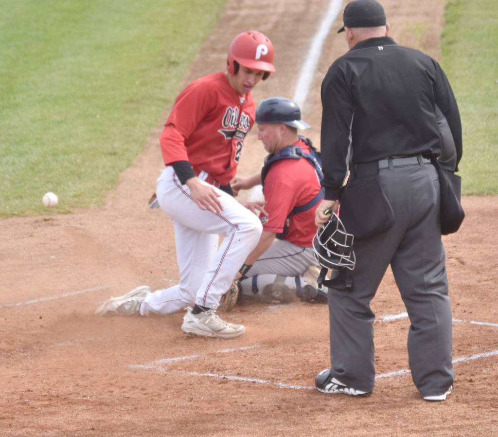 Colin Robson of the Peninsula Oilers slides in safe in front of Chugiak-Eagle River Chinooks catcher Dustin Isanogle during the second game of a doubleheader Sunday, July 14, 2024, at Coral Seymour Memorial Park in Kenai, Alaska. (Photo by Jeff Helminiak/Peninsula Clarion)