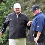 Beau Forrest congratulates George Collum after Collum rolled in a putt on No. 4 for a skin at the State Farm Agent Heith Groth Pro Am and Skins Game on Monday, July 15, 2024, at Birch Ridge Golf Course in Soldotna, Alaska. (Photo by Jeff Helminiak/Peninsula Clarion)