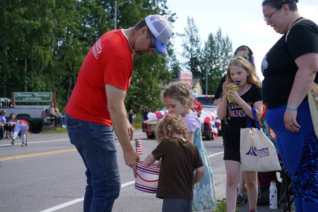 Sen. Jesse Bjorkman, R-Nikiski, gives candy to children while walking with the 67th Annual Soldotna Progress Days Parade on Marydale Avenue in Soldotna, Alaska, on Saturday, July 27, 2024. (Jake Dye/Peninsula Clarion)