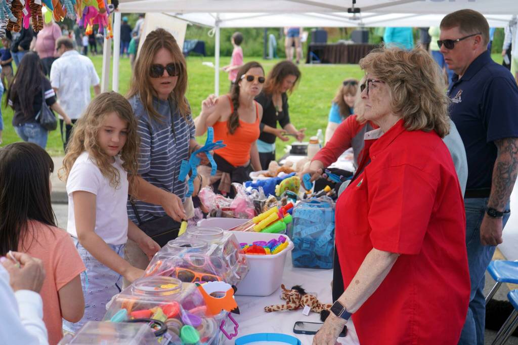 Children and parents mull their options while redeeming tickets during the Progress Days Block Party at Parker Park in Soldotna, Alaska, on Saturday, July 27, 2024. (Jake Dye/Peninsula Clarion)