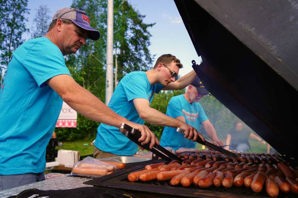 City of Soldotna representatives grill dozens of free hot dogs during the Progress Days Block Party at Parker Park in Soldotna, Alaska, on Saturday, July 27, 2024. (Jake Dye/Peninsula Clarion)