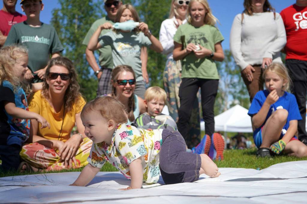 Tenzing Thiemann, 10-months-old, races forward to claim the Diaper Derby title during the Progress Days Block Party at Parker Park in Soldotna, Alaska, on Saturday, July 27, 2024. (Jake Dye/Peninsula Clarion)